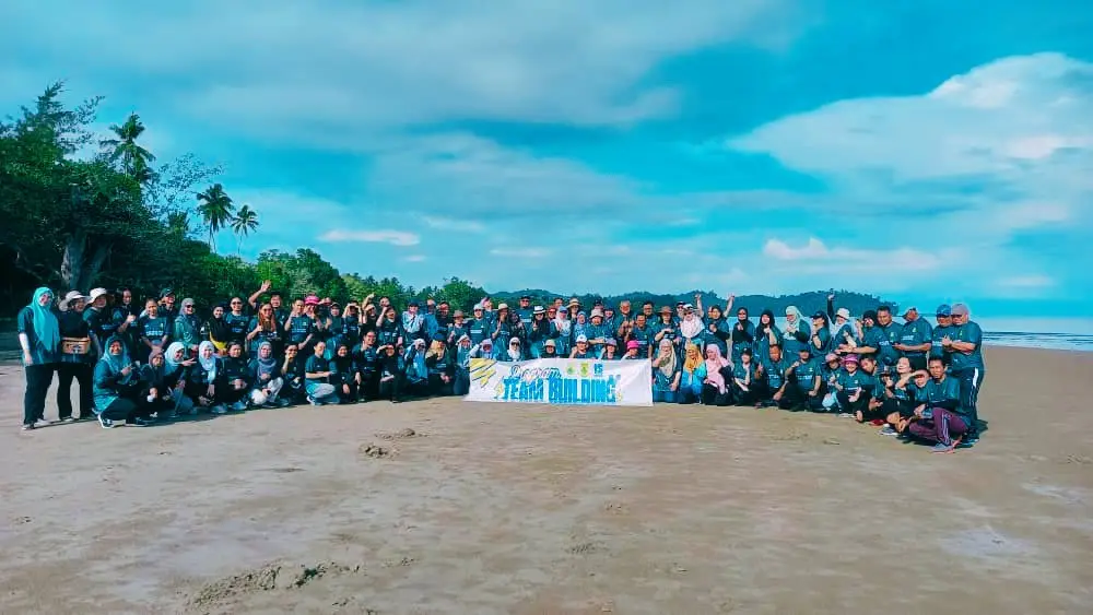 Kumpulan team building berkumpul di atas pasir Pantai Beringgis di hadapan Pasakon Beach
